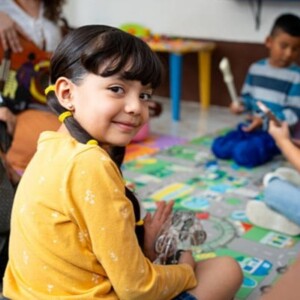 kids sitting around a playmat holding instruments